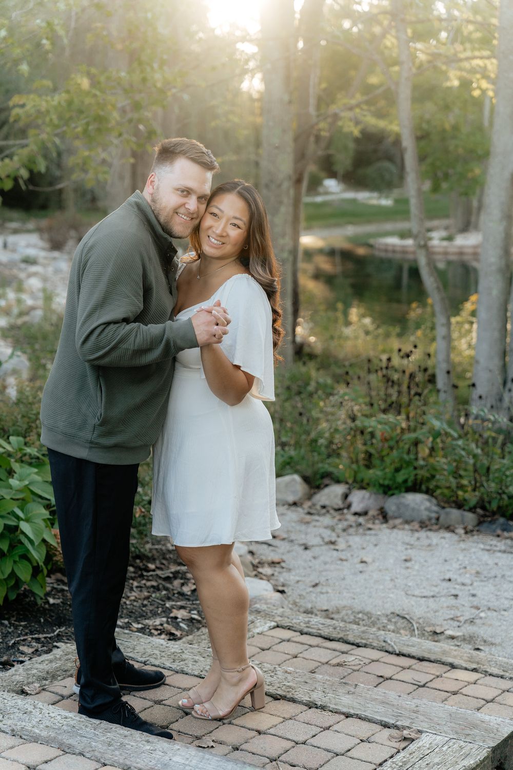 A couple sharing an intimate moment on a garden path at sunset.