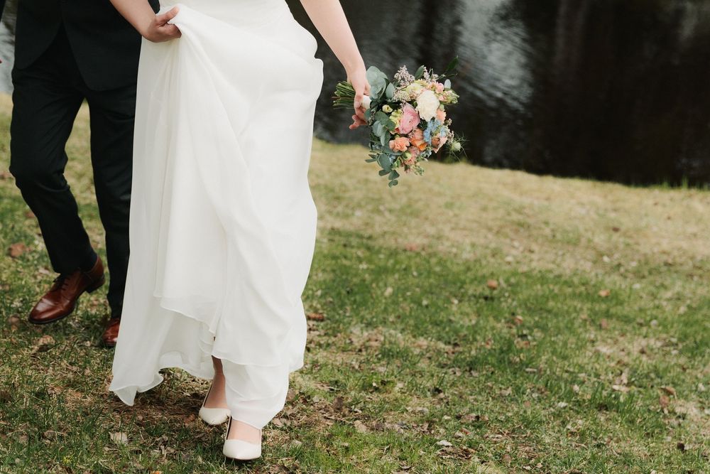 A series of wedding photos showing close-up details of shoes and dress hems on grassy ground.