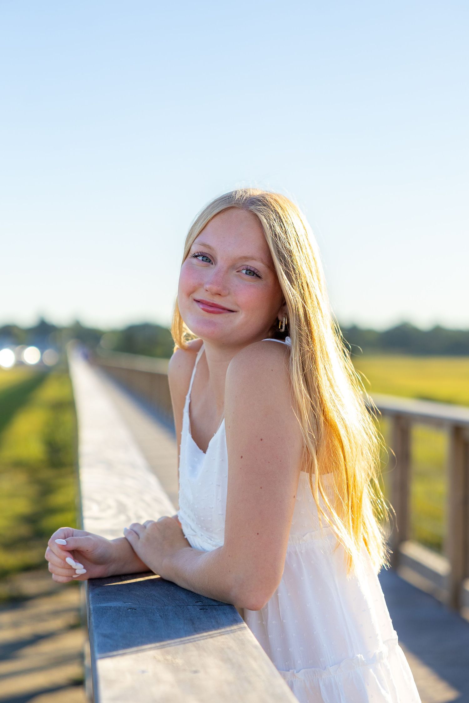 A romantic engagement photo session in a golden marsh field during sunset.