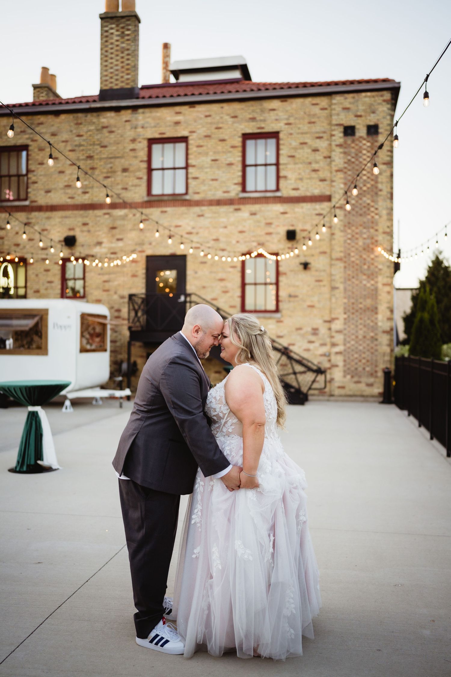 A romantic wedding couple shares intimate moments in a sequence of photos on a stone building patio.