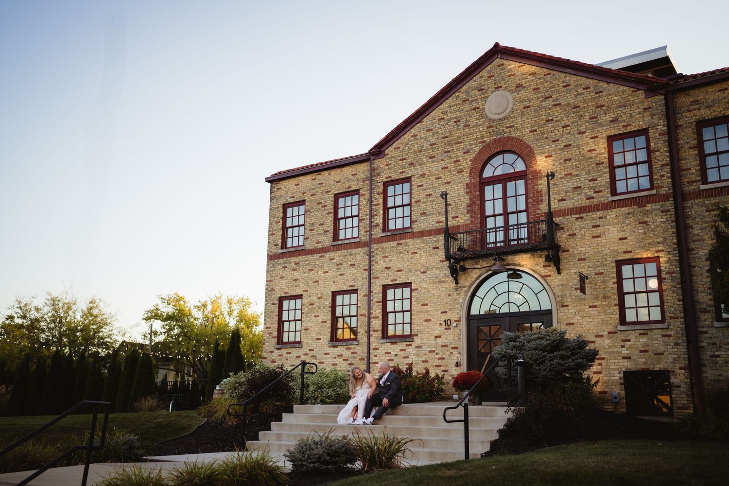 Historic stone building with arched windows and multiple architectural views showing its exterior features and landscaping.