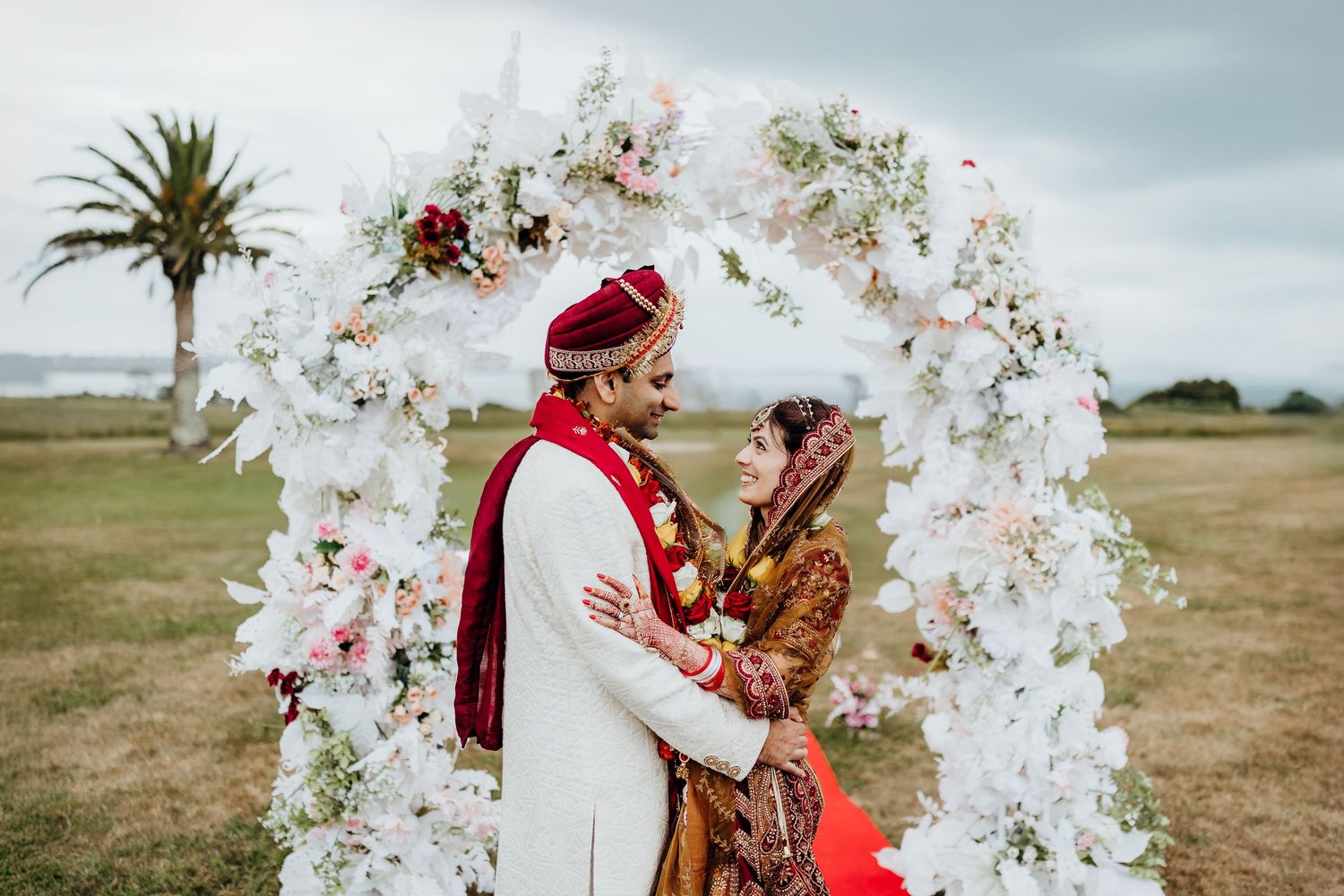 Wedding guests toss colorful confetti in celebration during an outdoor ceremony.