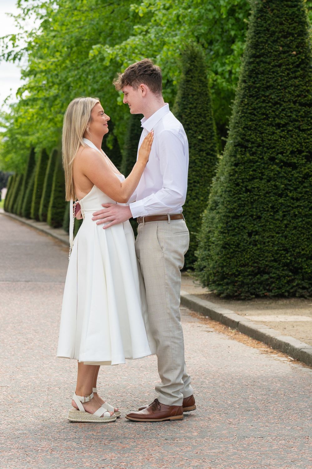 Intimate dance moment on tree-lined pathway.