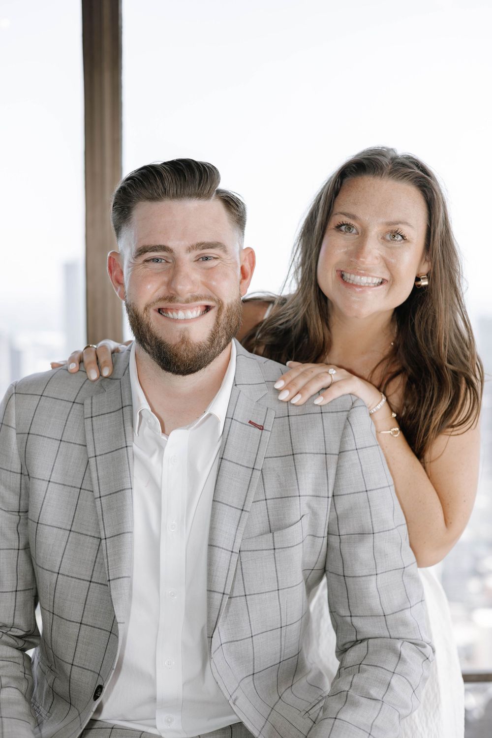 A couple in matching gray plaid blazers and white shirts share joyful moments in three sequential photos.