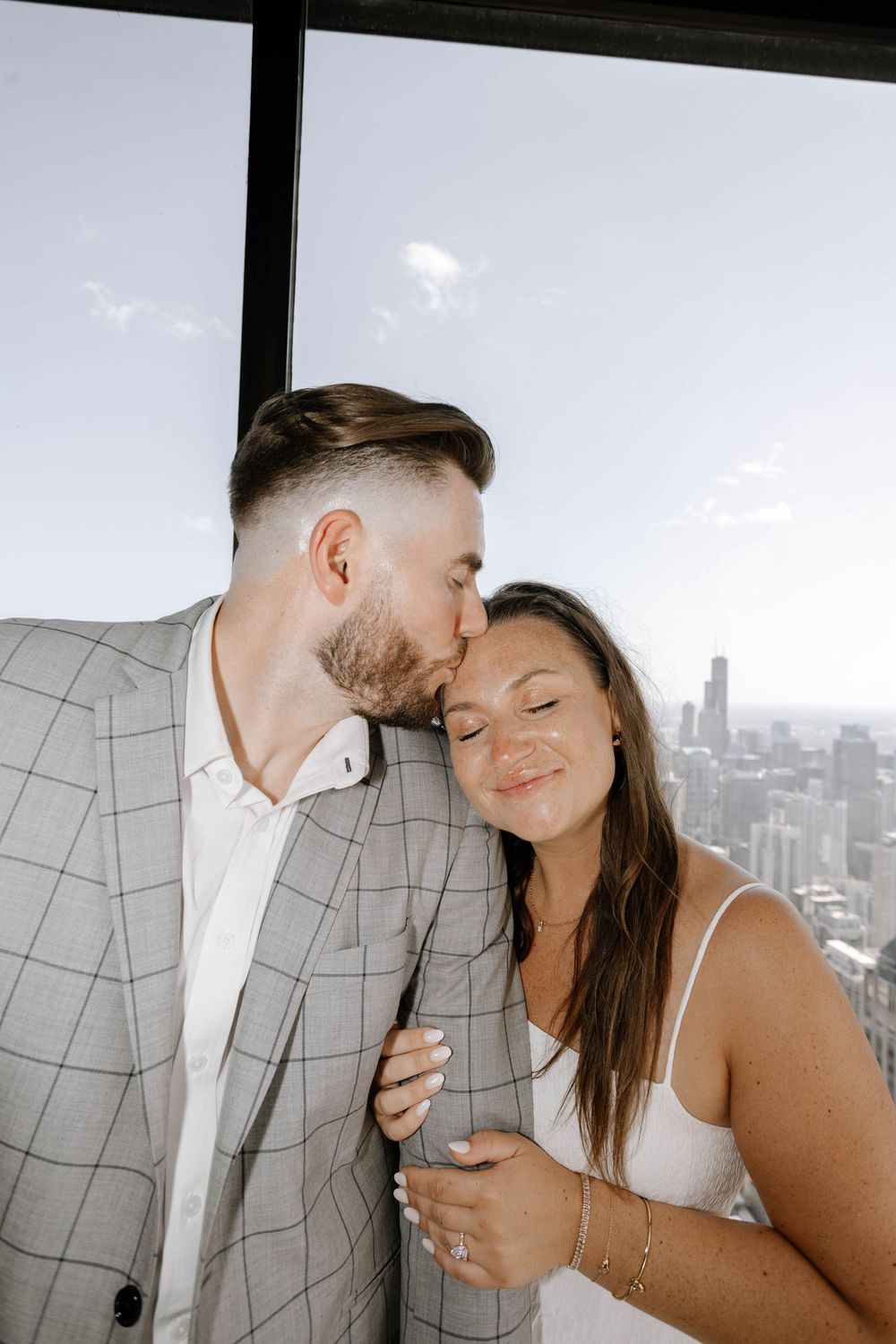 A couple shares an intimate moment against a city skyline backdrop through a series of progressive romantic poses.