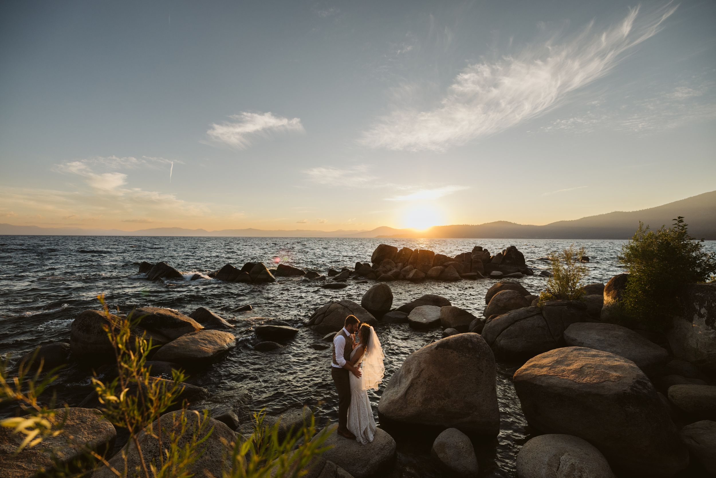 Scenic coastal sunset with rocky shoreline and ocean waves.
