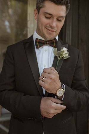 Close-up shots of groom adjusting boutonniere and bow tie before ceremony.