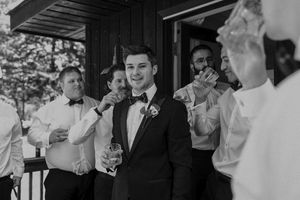 Wedding party members sharing drinks and laughs during reception.