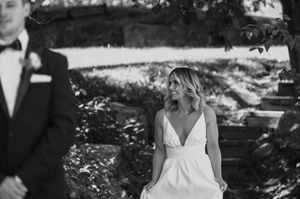 Black and white artistic portrait of newlyweds in an outdoor garden setting.
