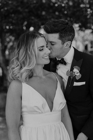 Intimate black and white wedding portraits of a couple sharing romantic moments outdoors.