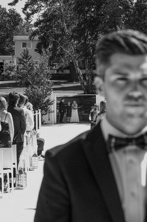 Black and white candid wedding moments captured with guests and wedding party outdoors.