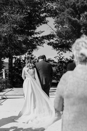 Black and white wedding ceremony scene with flowing bridal gown.