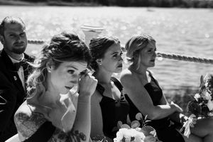 Wedding guests react emotionally during outdoor ceremony.
