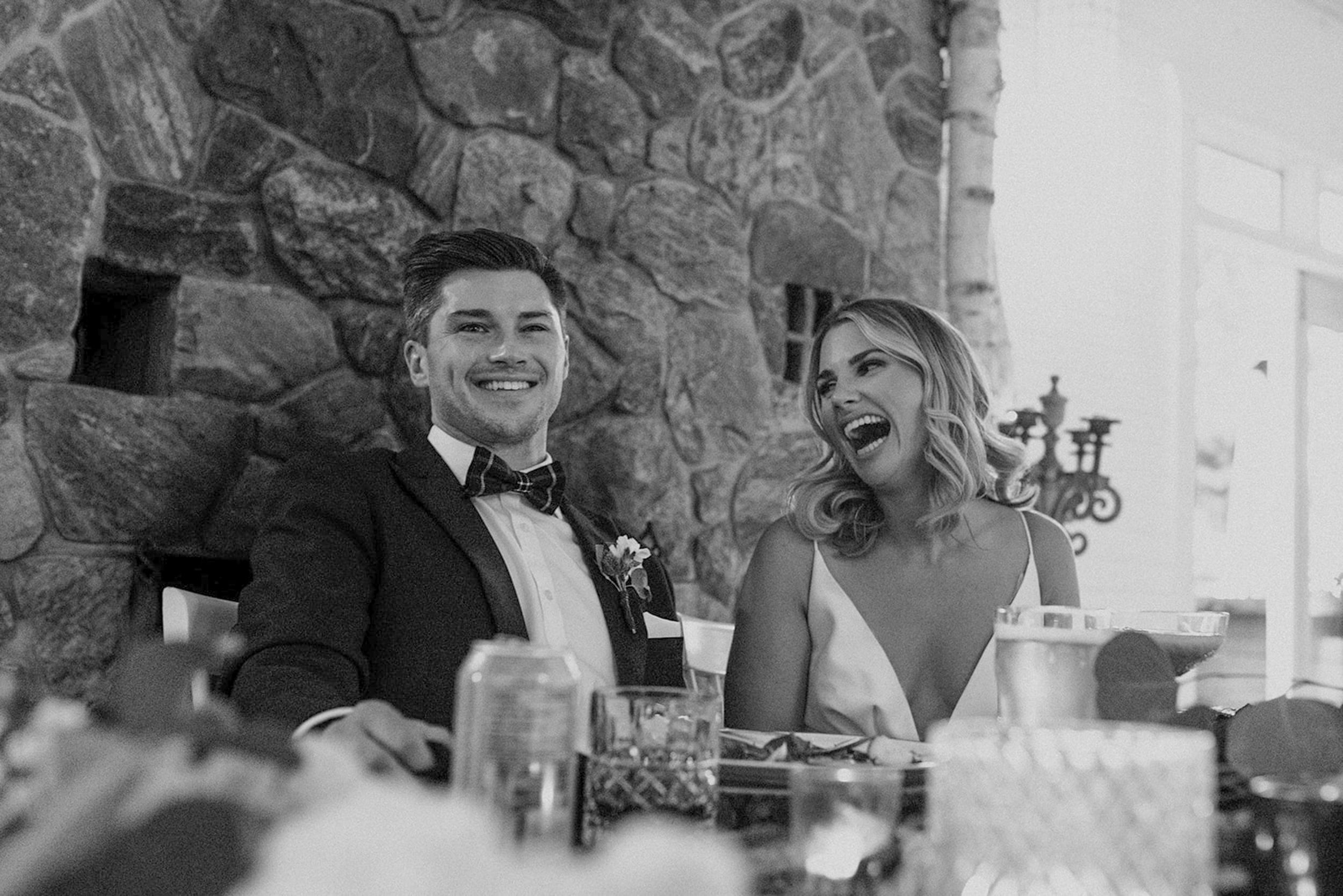 Black and white candid shots of wedding guests laughing and mingling during an outdoor celebration.