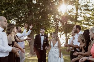 Wedding couple shares intimate moments during golden hour in a wooded outdoor setting.