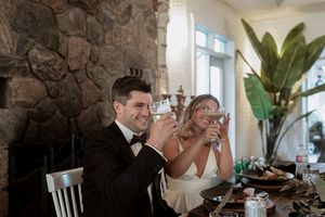 Wedding couple shares an intimate moment in a rustic stone-walled venue with elegant lighting.