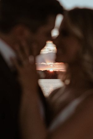 Scenic sunset over water captured through silhouetted foliage in a romantic sequence of shots.