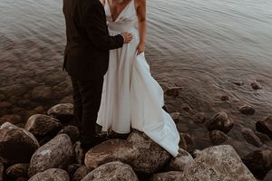 Couple explores rocky shoreline during their winter wedding photoshoot.