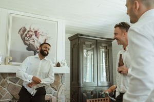 Wedding party members in white shirts getting ready indoors.