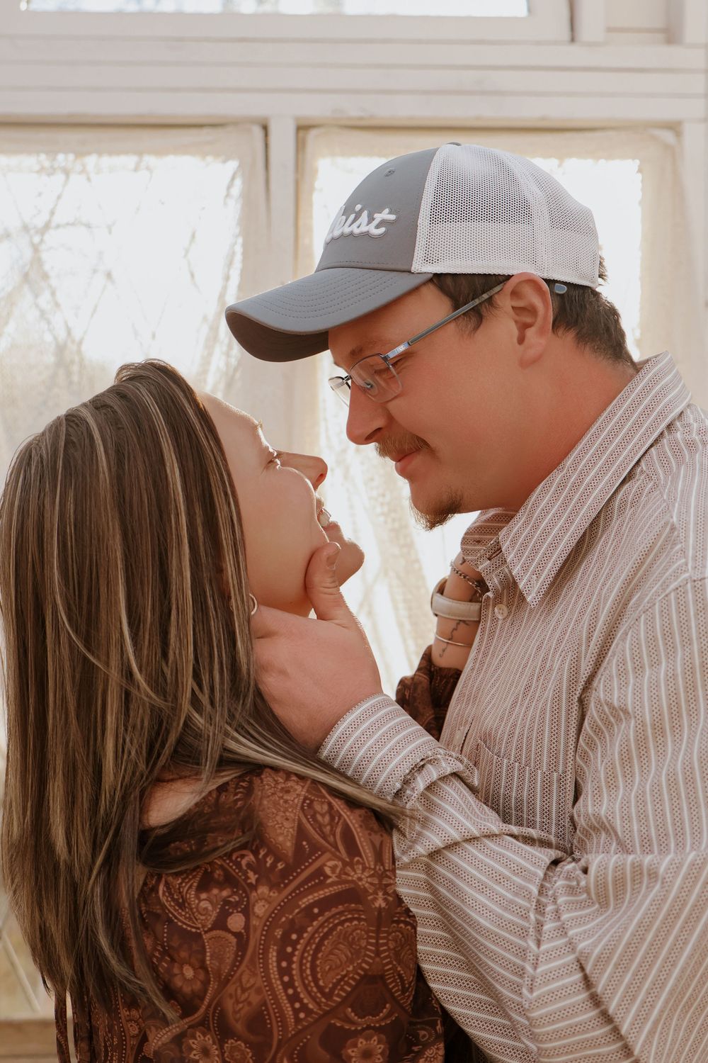Romantic couple laughing together during indoor photo session.