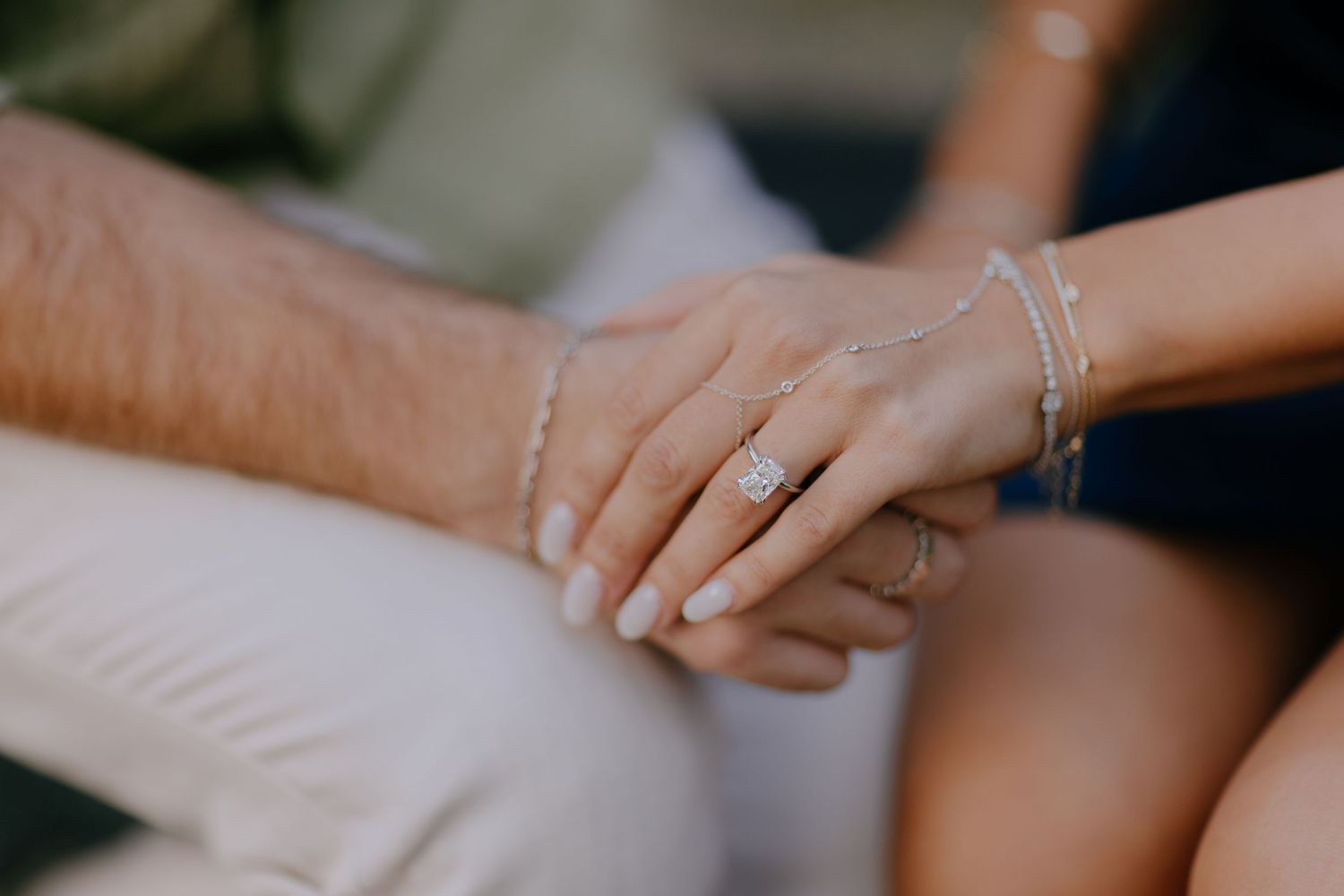 Close-up shot of hands with delicate silver bracelets and rings touching in an intimate moment at Hakone Japan