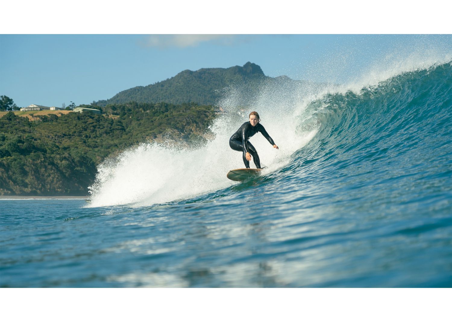photo of a girl tucking into a near barrel in Raglan, New Zealand showing ways to frame a video for beginner surf videographers