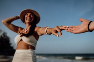 Couple holding hands and walking on beach during sunset with soft waves in background.
Azulik Tulum