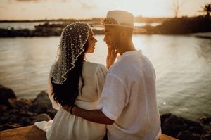 A romantic couple embraces during golden hour sunset at a scenic outdoor location. Kima Tulum