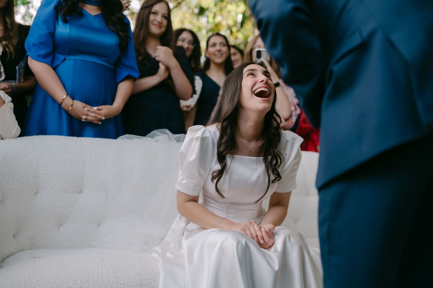 Joyful candid moments captured between wedding party members in formal attire.