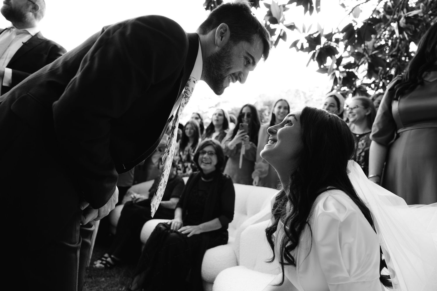 A black and white photo montage showing intimate moments from a wedding celebration with guests and dancing.