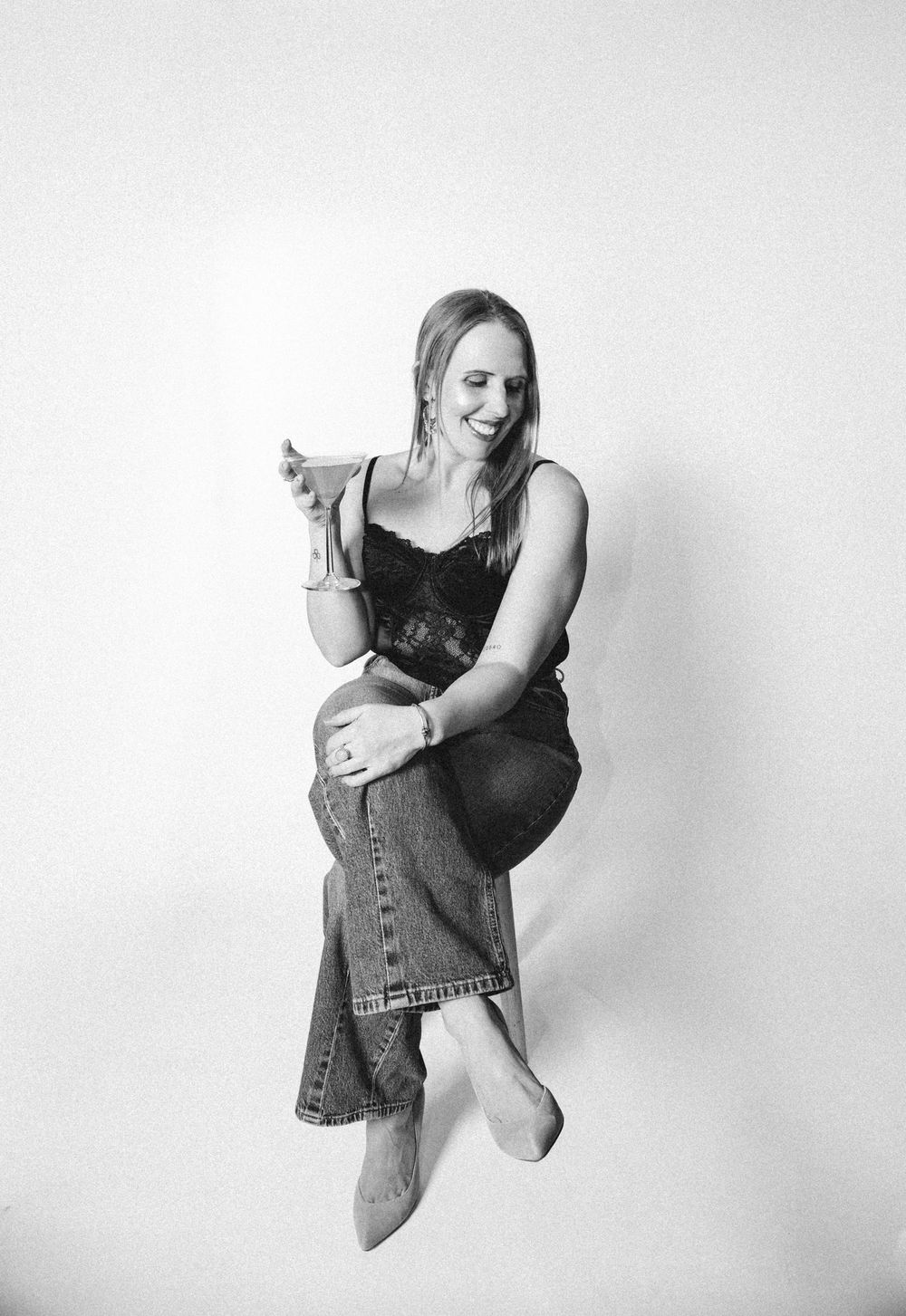 A black and white photo series showing a person in denim vest striking dynamic dance-like poses against a plain wall.