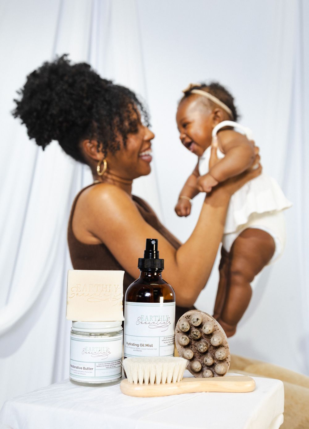 Product photography setup with hair care items and brush against white backdrop.
