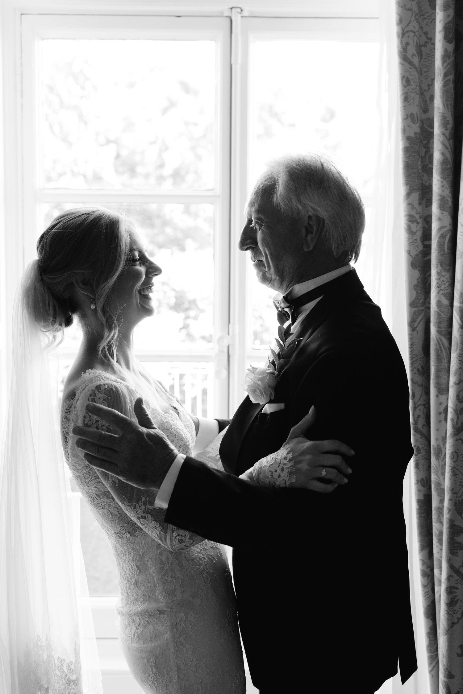 A romantic sequence of silhouettes showing a couple in formal attire embracing by a bright window.