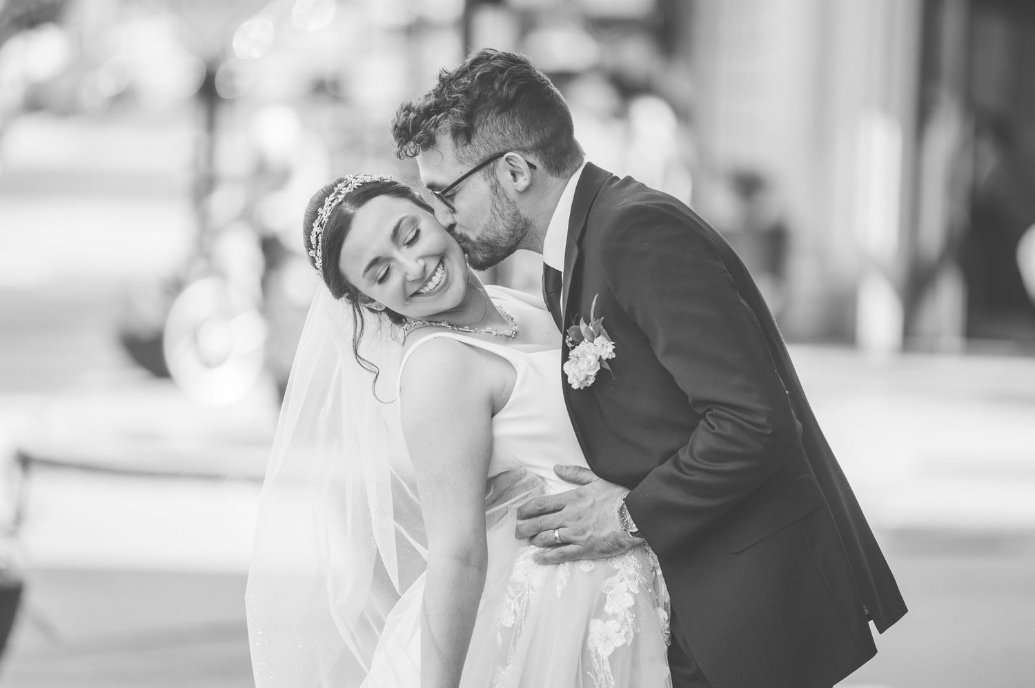 A tender black and white wedding moment captured as newlyweds embrace during their special day.