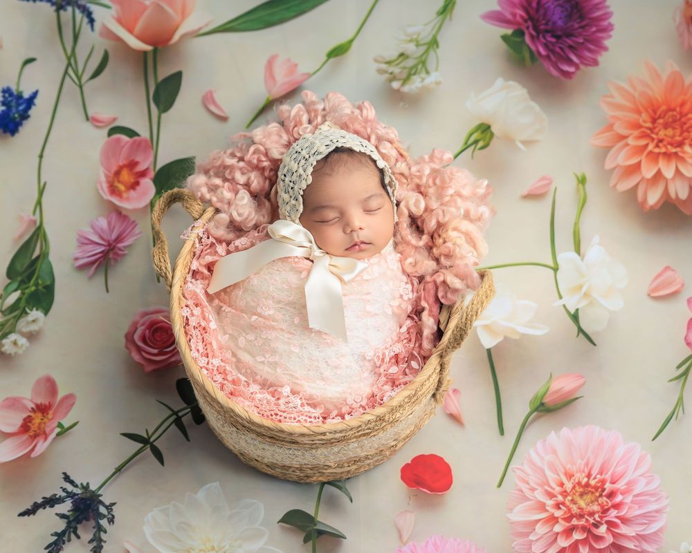 Delicate floral arrangement with pink dahlias and scattered petals on a light background with soft natural lighting.