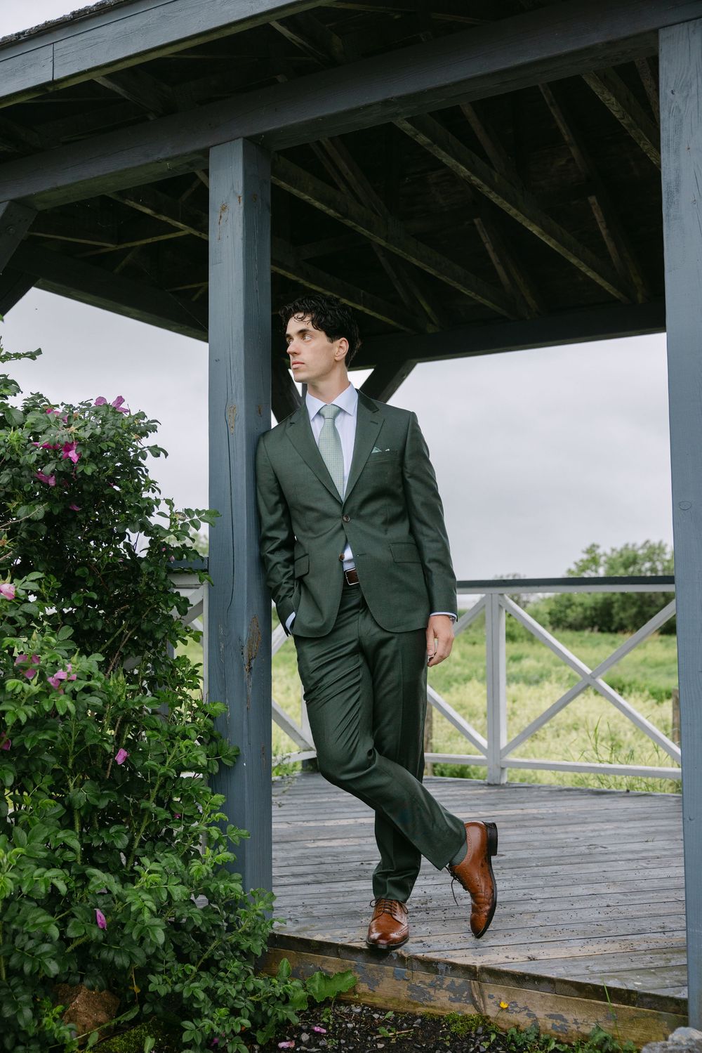 Professional business portrait session on a rustic wooden deck with architectural beams and green foliage.