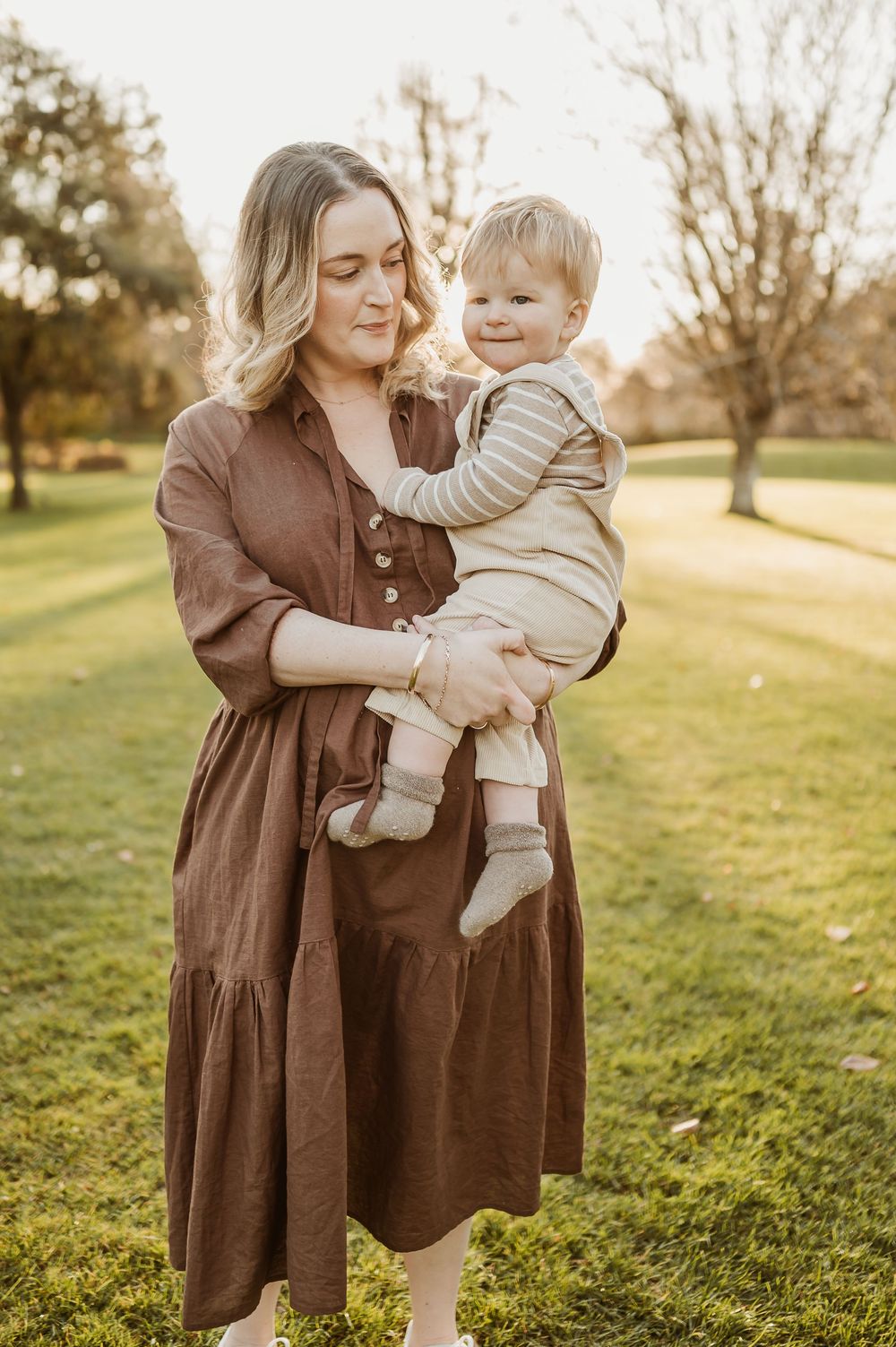 A tender moment shared between parent and child in a sunny park setting.