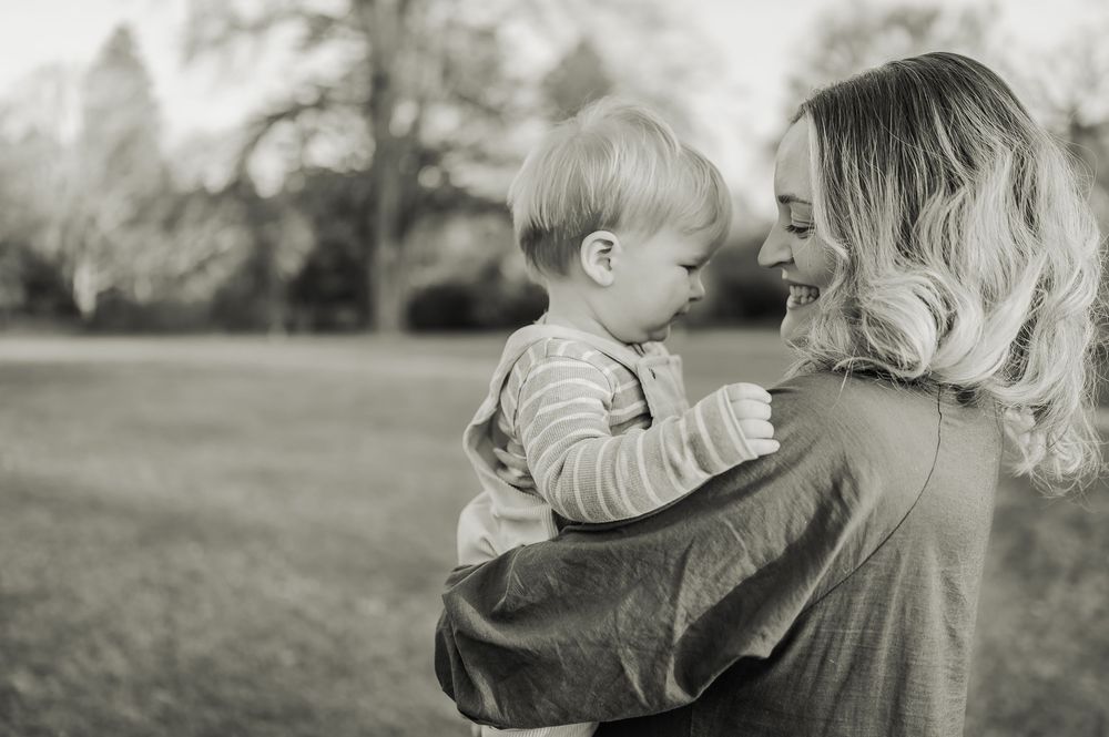 Black and white photo sequence showing tender moments between a parent and child outdoors in nature.