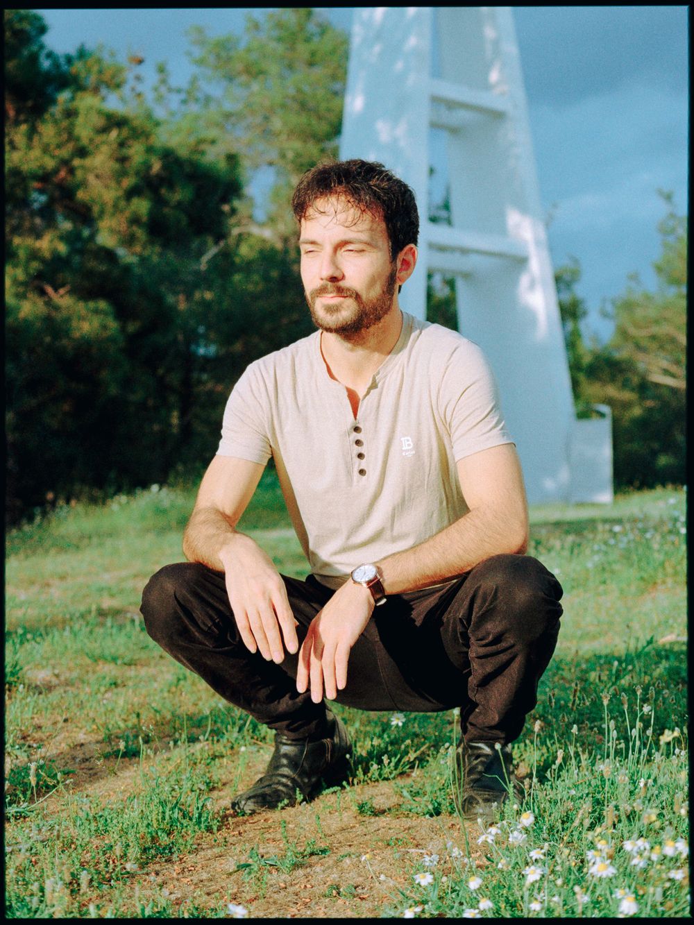 Outdoor film portrait of a man seated casually in natural light.