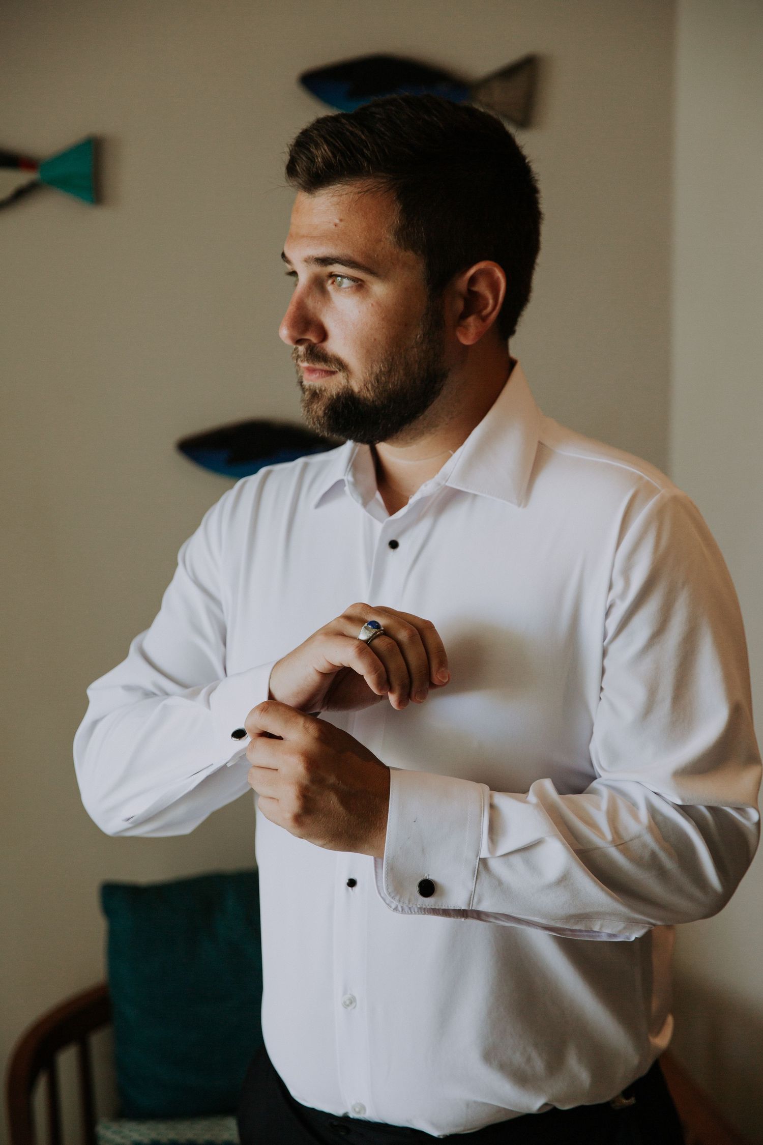 A formal white dress shirt being buttoned during wedding preparations.
