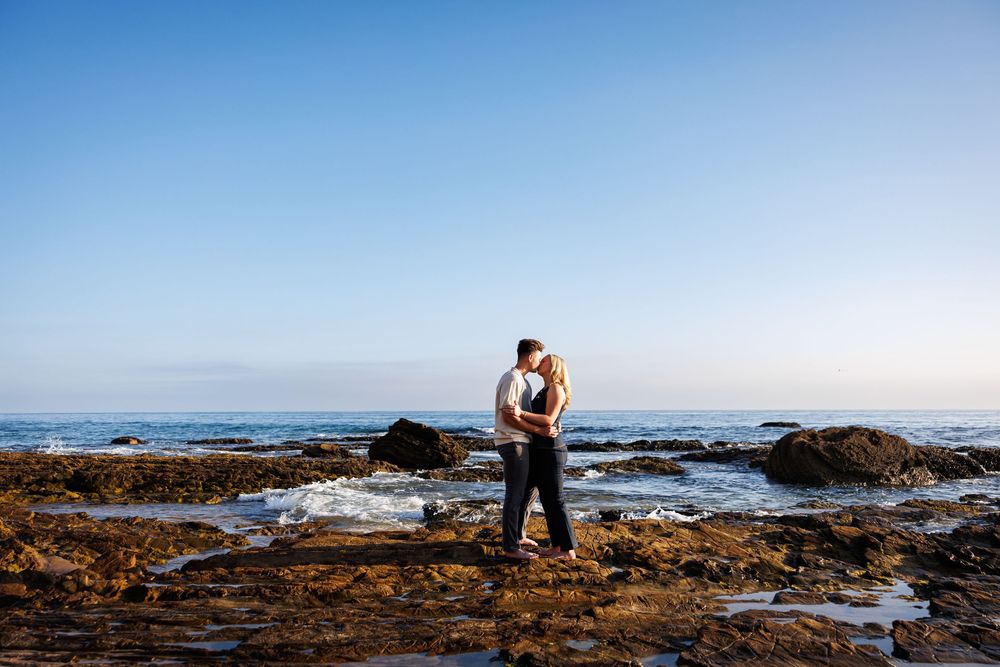 Silhouetted couple embracing at sunset near the ocean shore in Newport Beach at Crystal Cove.