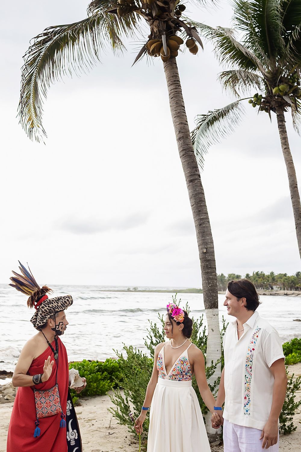 A beach wedding scene with palm trees along a tropical shoreline.