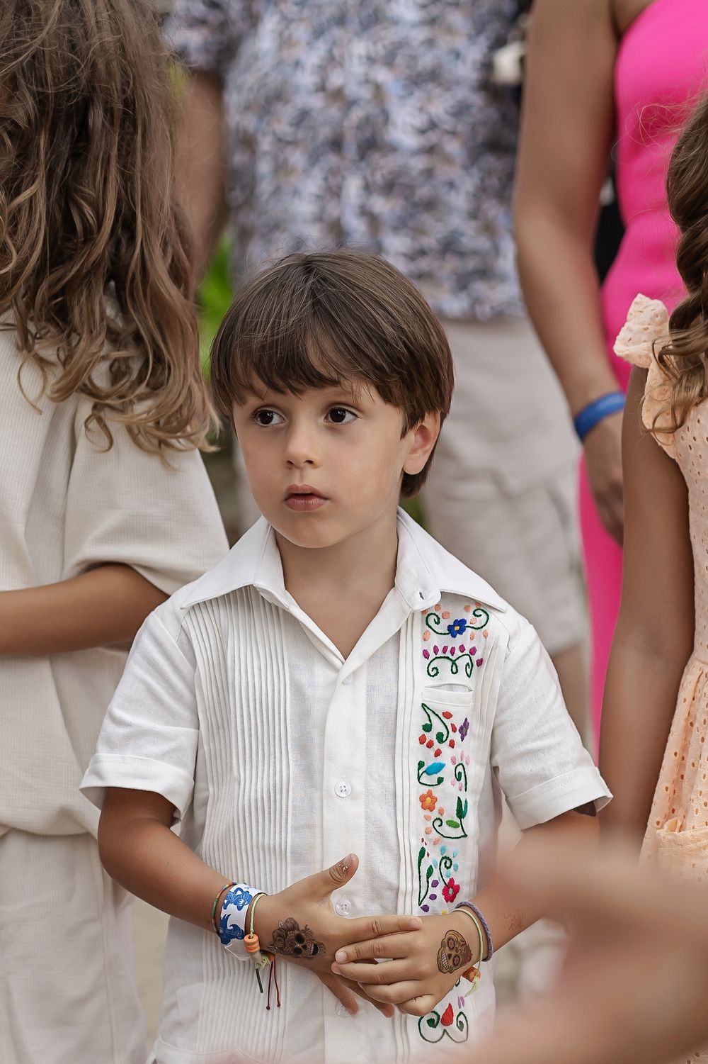 Young festive attendee wearing white embroidered shirt at a celebration.