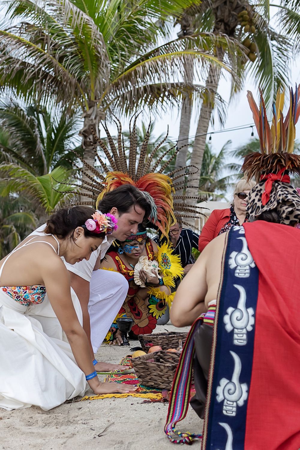Colorful beach ceremony scene with tropical palm trees and decorative ceremonial elements in Costa Maya, Mexico.