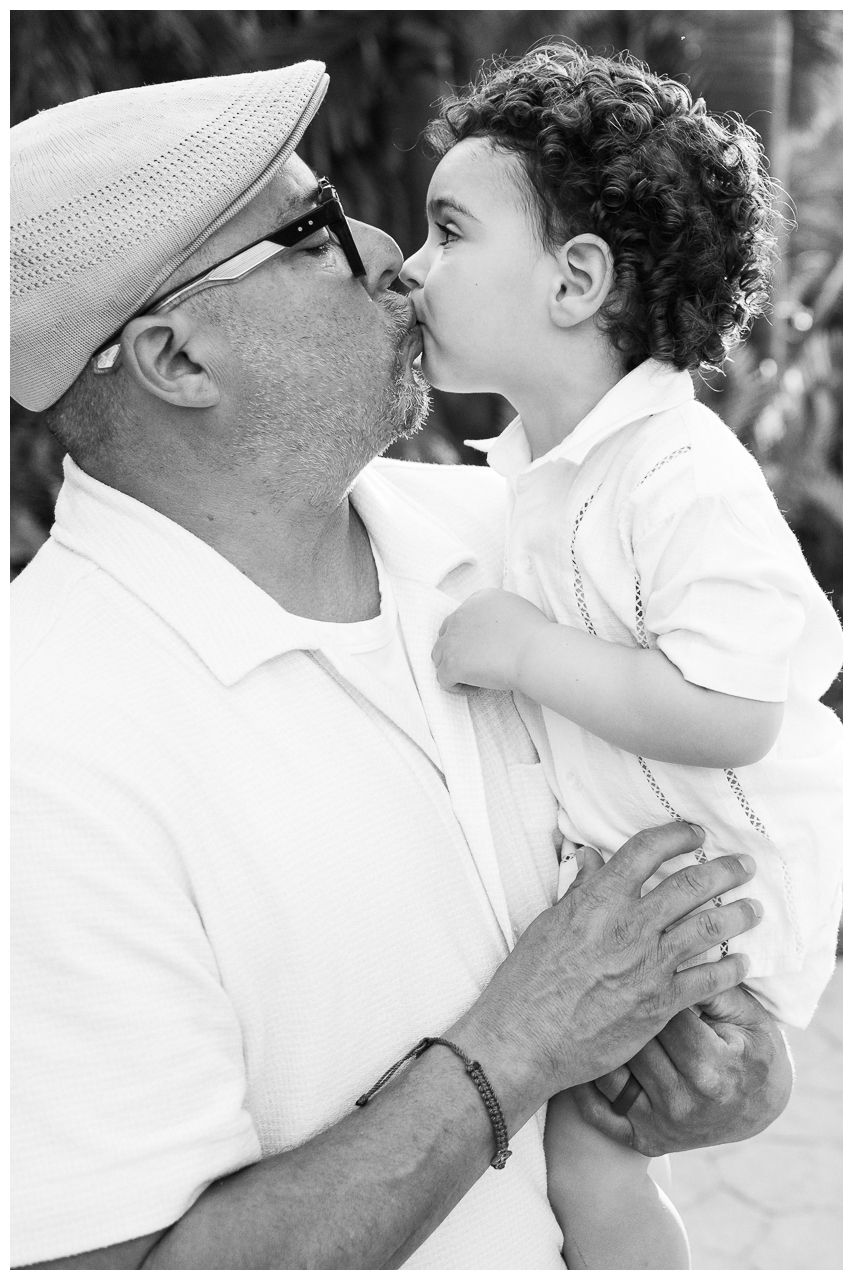 Black and white sequence showing tender embraces and loving kisses in a family moment captured across multiple frames.