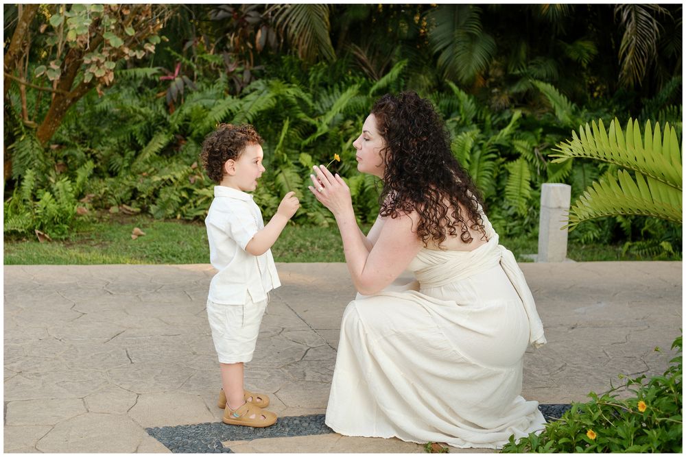 Family enjoys special outdoor moments together in a lush garden setting with white outfits.