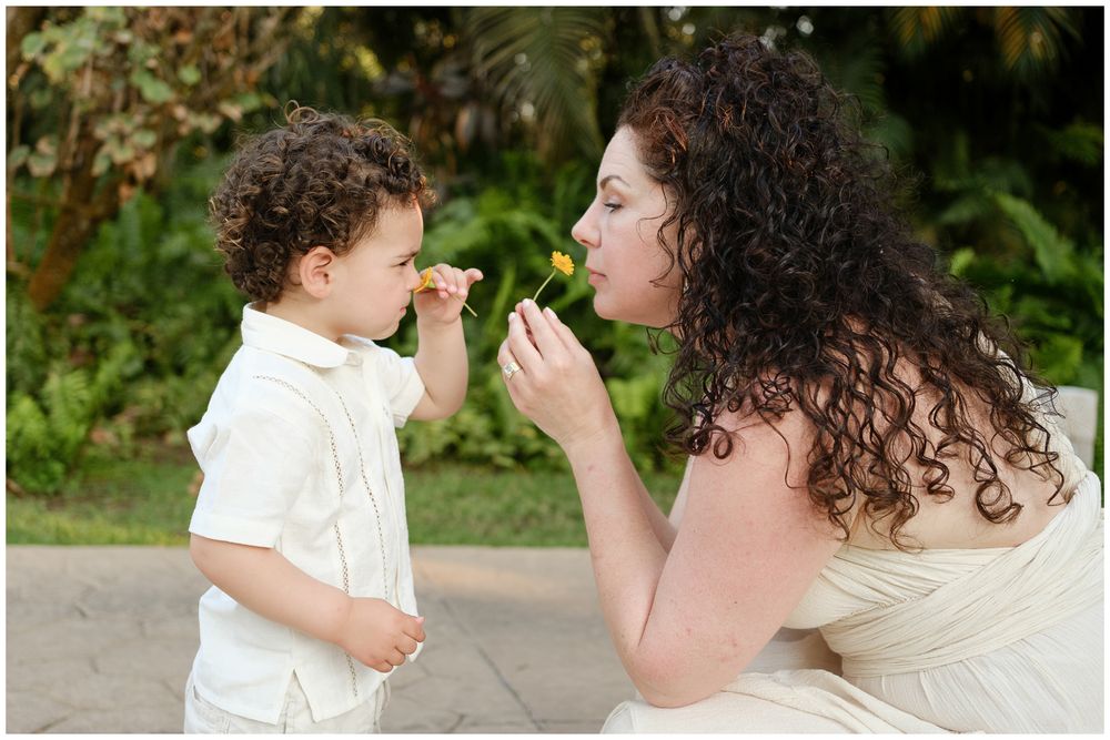 Parent and child share an intimate moment while playing together in a lush green outdoor setting.
