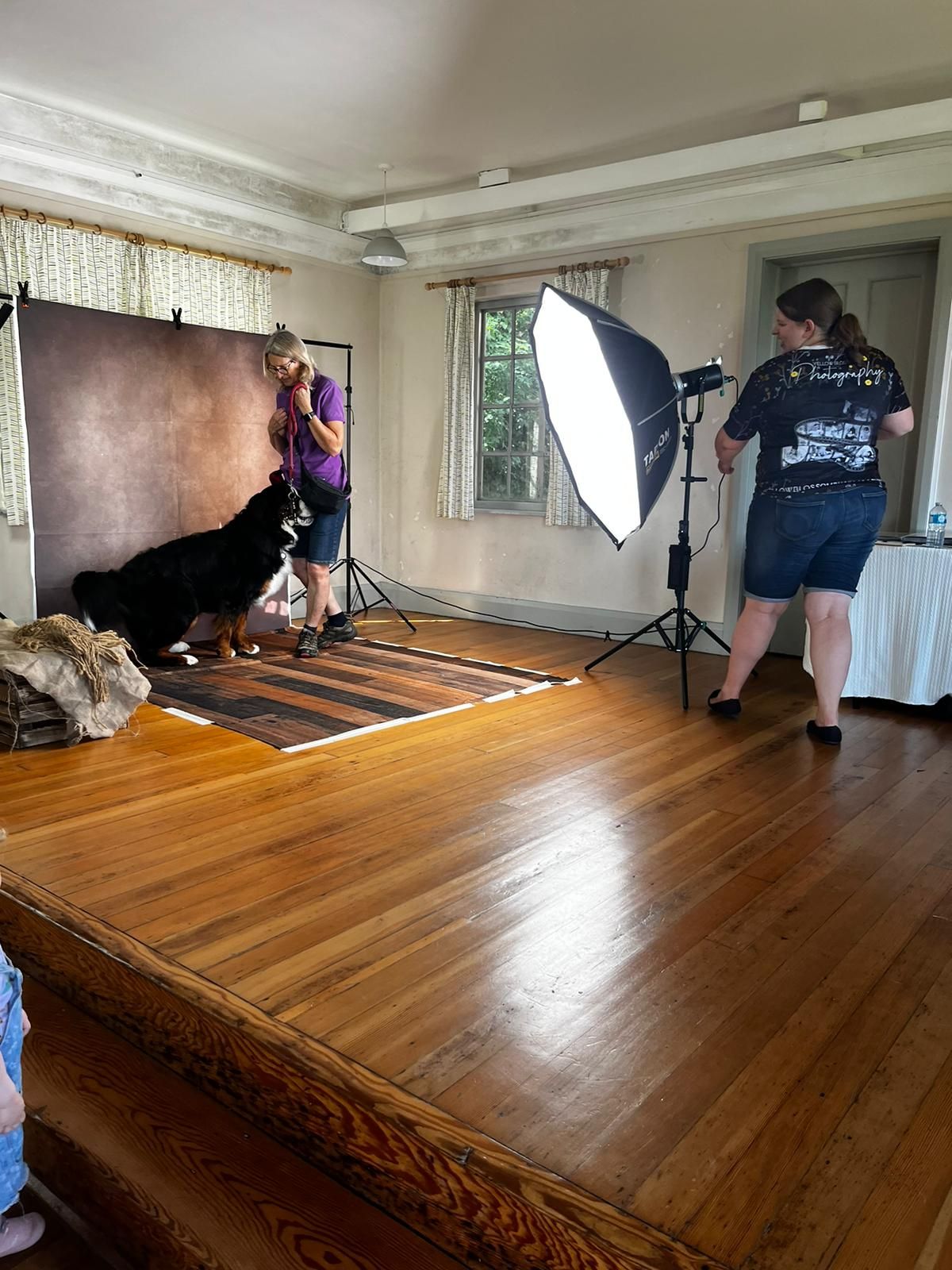 Photography studio setup with professional lighting equipment and wooden floor backdrop for commercial product shoot.
