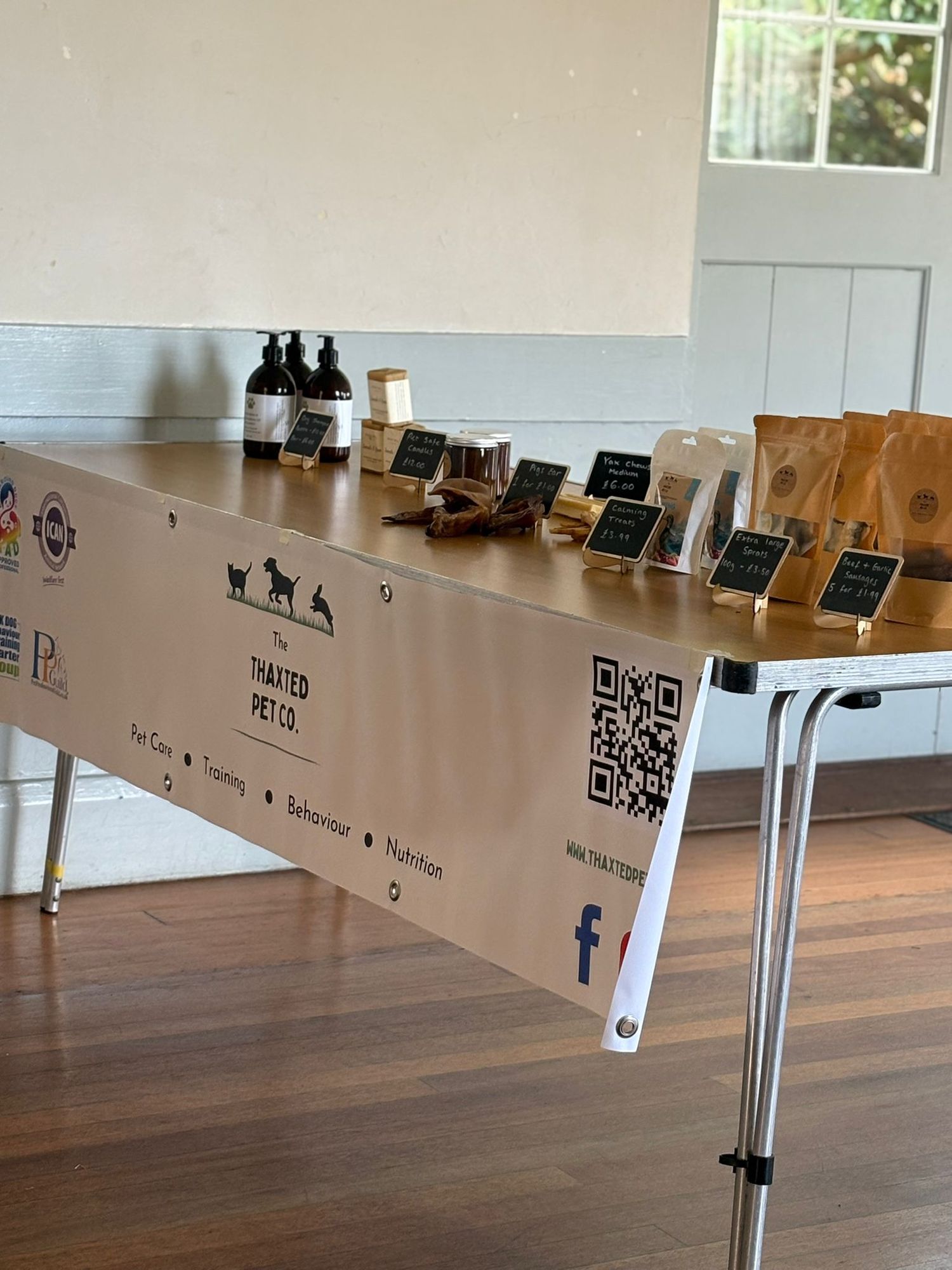 A display table with QR codes and product bottles arranged in a row for customer scanning and ordering.