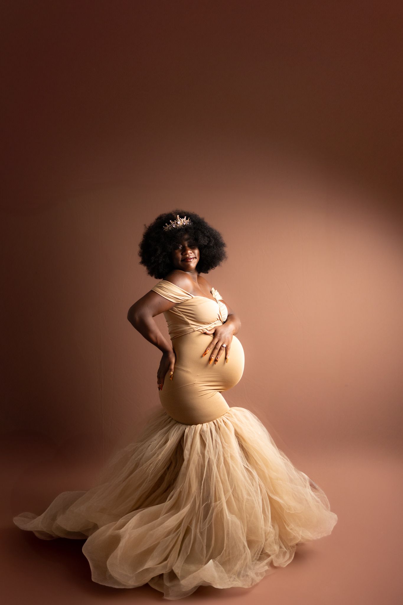 A figure in a tan bodysuit and flowing tulle skirt spins gracefully in a sunlit room with white curtains.